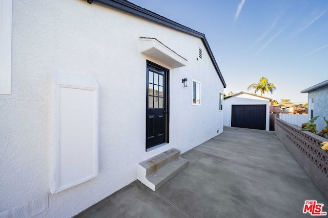 view of side of home featuring a garage and an outbuilding