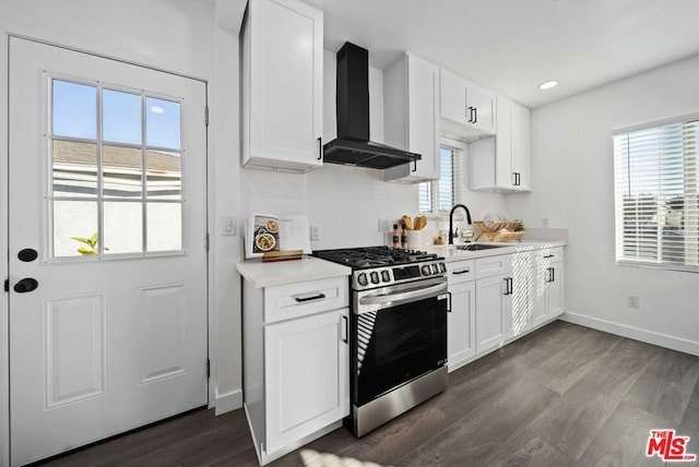 kitchen featuring wall chimney exhaust hood, white cabinetry, sink, dark hardwood / wood-style floors, and stainless steel range with gas cooktop