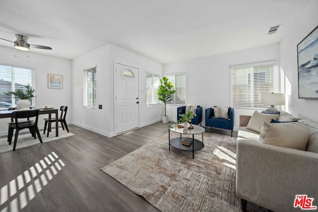 living room featuring ceiling fan and dark wood-type flooring