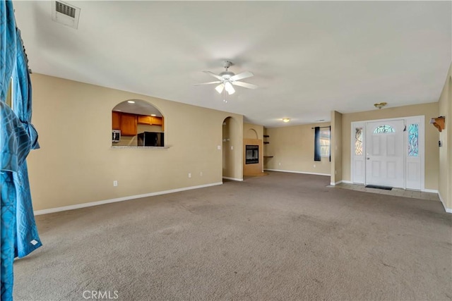 unfurnished living room with ceiling fan and carpet floors