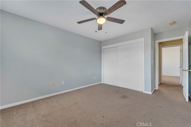 unfurnished bedroom featuring ceiling fan, light carpet, and a closet