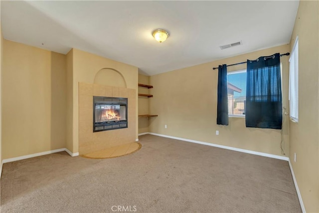 unfurnished living room featuring carpet floors and a fireplace