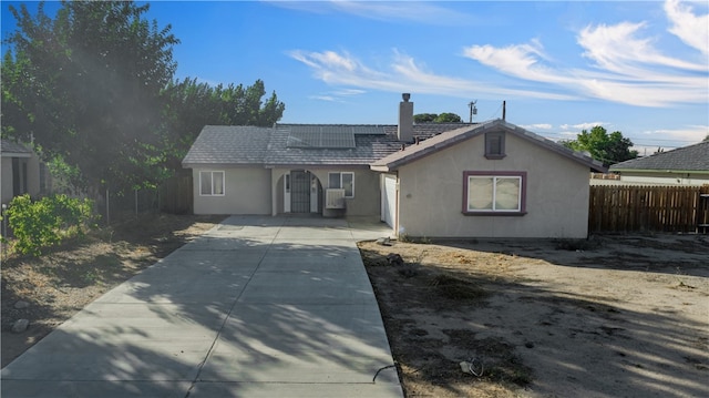 ranch-style house featuring solar panels