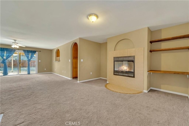 unfurnished living room featuring light carpet, ceiling fan, and a tile fireplace