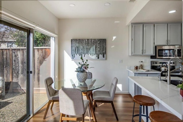 dining area with sink and hardwood / wood-style floors