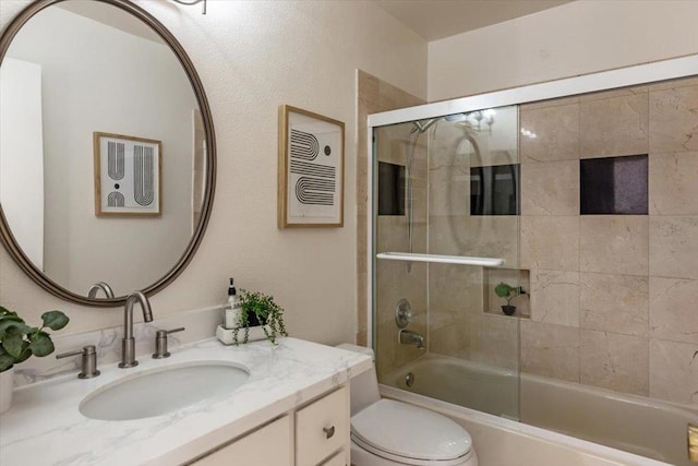 full bathroom with toilet, vanity, and shower / bath combination with glass door