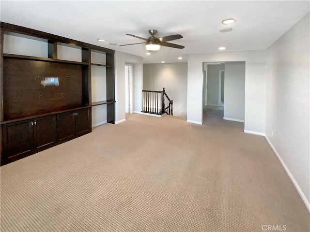 unfurnished living room with ceiling fan and light colored carpet