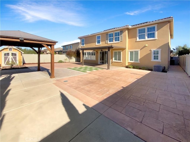 back of property with a shed, a gazebo, a patio area, and central air condition unit