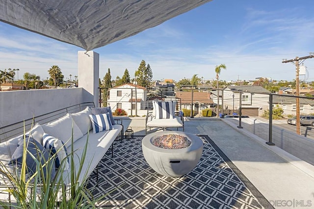 view of patio with an outdoor living space with a fire pit