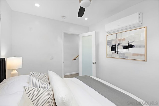 bedroom featuring ceiling fan and a wall unit AC