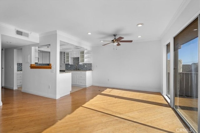 unfurnished living room featuring ceiling fan, ornamental molding, and light hardwood / wood-style flooring