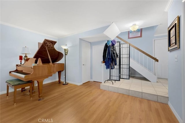 misc room with light hardwood / wood-style floors, ornamental molding, and a chandelier