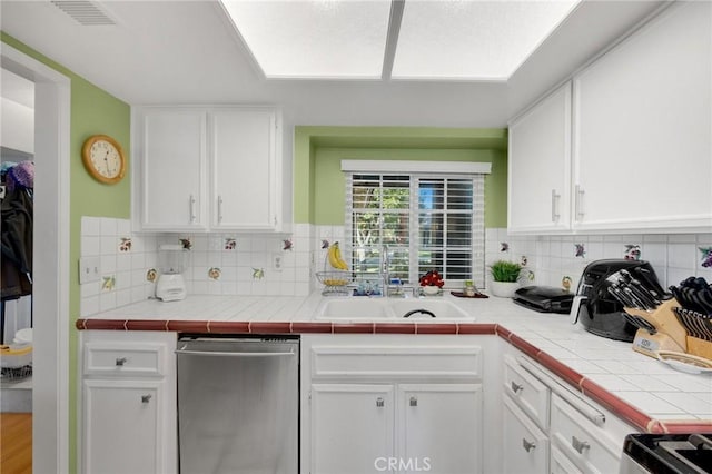 kitchen featuring white cabinetry, tile counters, tasteful backsplash, and sink