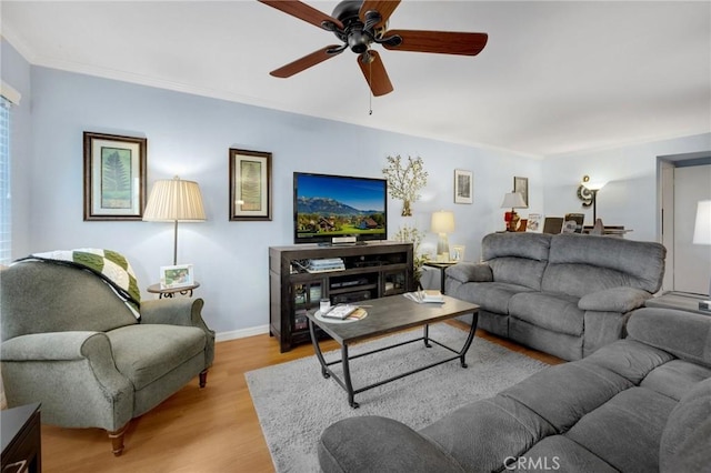 living room featuring light wood-type flooring, ceiling fan, and crown molding