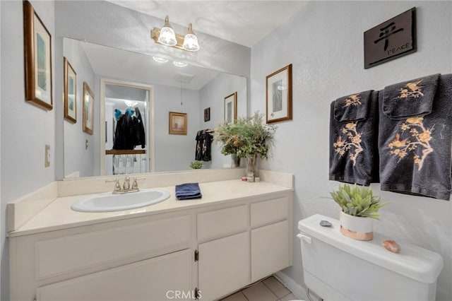 bathroom featuring tile patterned floors, toilet, and vanity