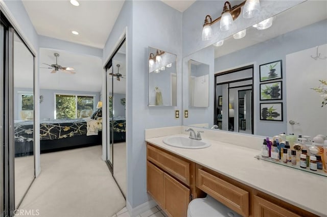 bathroom with ceiling fan, vanity, and lofted ceiling