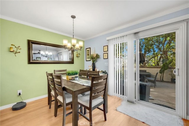 dining area with a notable chandelier, ornamental molding, and light hardwood / wood-style floors