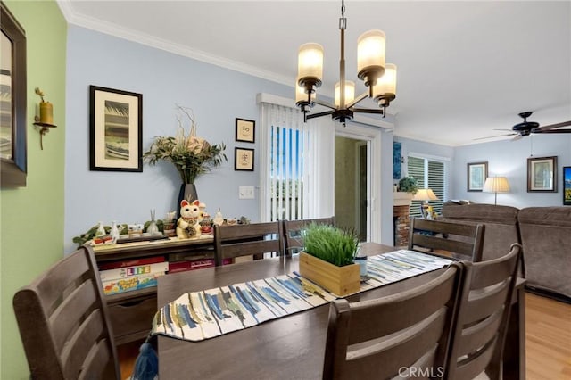 dining space with ceiling fan with notable chandelier, ornamental molding, and hardwood / wood-style flooring