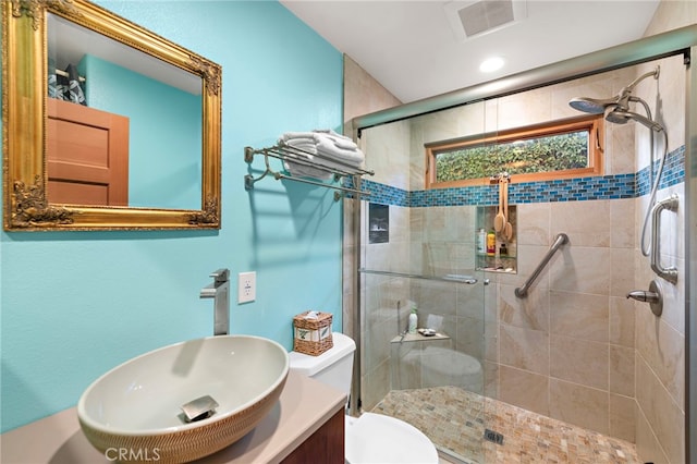 bathroom with vanity, a shower with shower door, and toilet