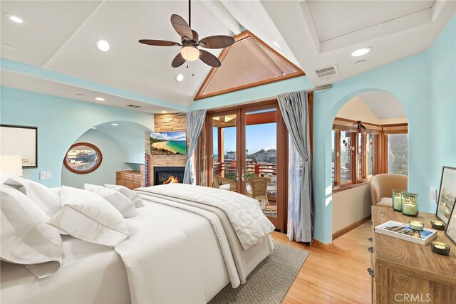 bedroom featuring multiple windows, access to outside, high vaulted ceiling, and light wood-type flooring