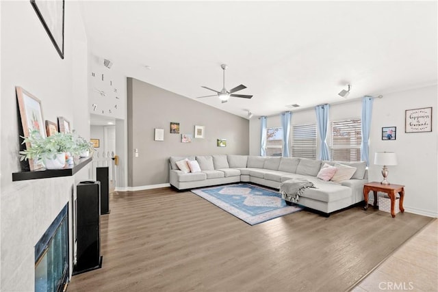 living room featuring vaulted ceiling, ceiling fan, and hardwood / wood-style flooring