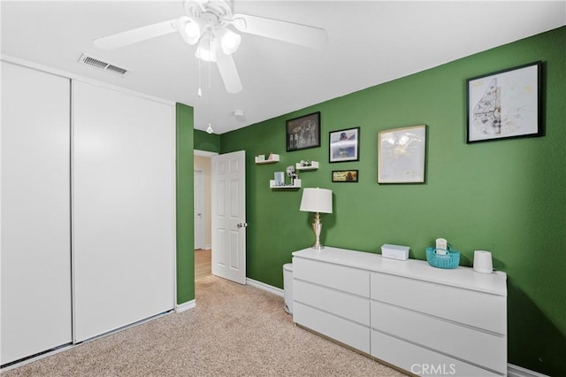 carpeted bedroom with ceiling fan and a closet