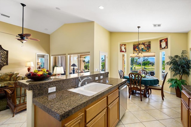 kitchen featuring lofted ceiling, dishwasher, sink, an island with sink, and ceiling fan with notable chandelier