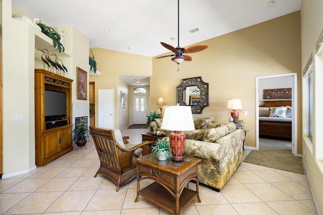 tiled living room with ceiling fan and high vaulted ceiling