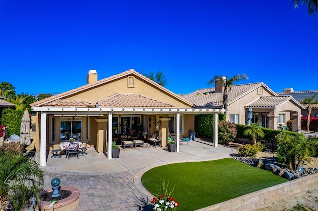 back of house featuring a patio area, a lawn, and an outdoor hangout area