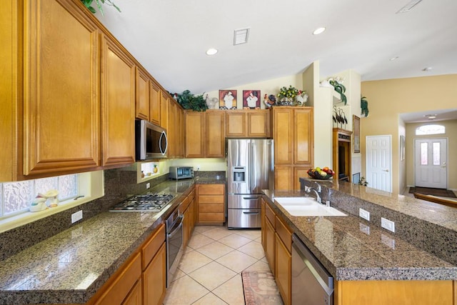 kitchen featuring light tile patterned floors, a center island with sink, appliances with stainless steel finishes, backsplash, and sink