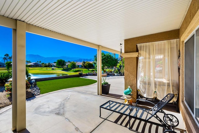 view of patio / terrace featuring a water and mountain view