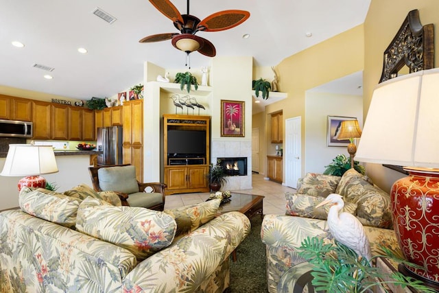 tiled living room featuring ceiling fan and a tile fireplace