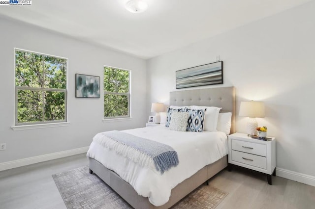 bedroom featuring light wood-type flooring and multiple windows