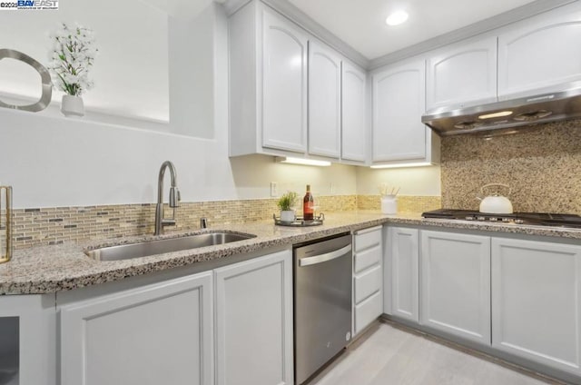 kitchen featuring appliances with stainless steel finishes, white cabinetry, light stone counters, and sink