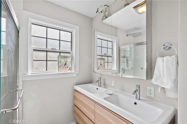 bathroom featuring vanity and a shower with door