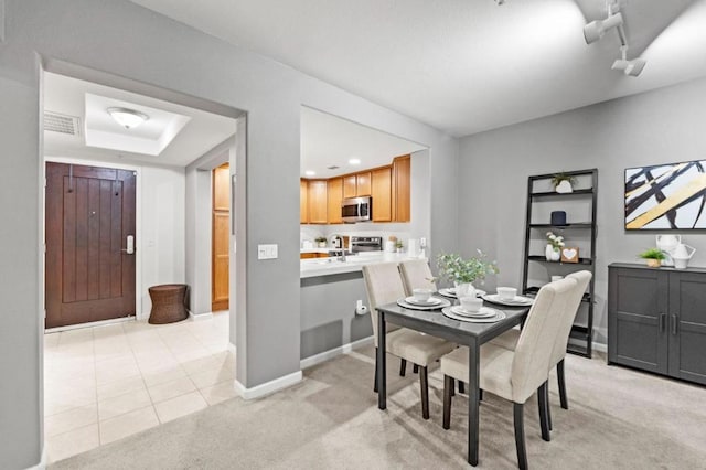 dining room featuring sink and light colored carpet