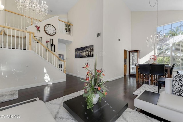 living room with high vaulted ceiling, dark wood-type flooring, and a notable chandelier