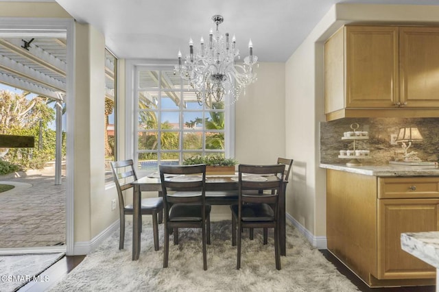 dining room with light wood-type flooring and a notable chandelier