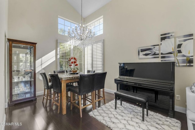 dining area with high vaulted ceiling, dark hardwood / wood-style floors, and a chandelier