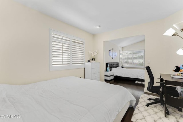 bedroom with vaulted ceiling and dark hardwood / wood-style floors