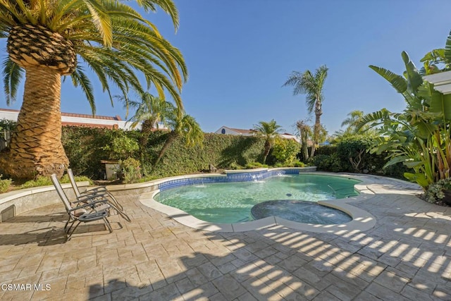 view of swimming pool featuring a patio area and an in ground hot tub