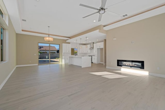 unfurnished living room featuring ceiling fan and light hardwood / wood-style flooring