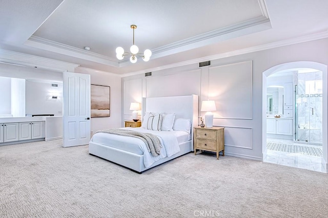 bedroom featuring carpet floors, a tray ceiling, and arched walkways