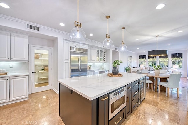 kitchen featuring glass insert cabinets, white cabinetry, visible vents, and built in appliances