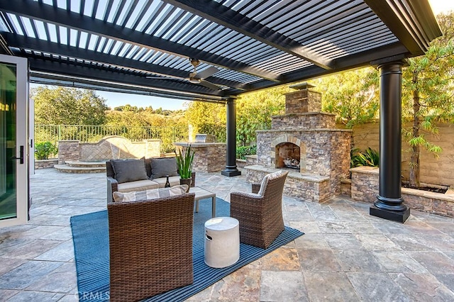 view of patio featuring an outdoor living space with a fireplace, fence, and a pergola