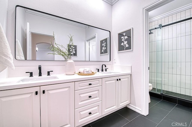 full bath with a shower stall, a sink, toilet, and tile patterned floors