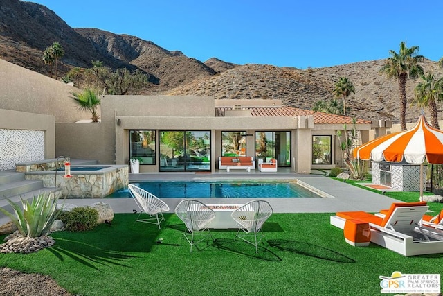 view of swimming pool with an in ground hot tub and a mountain view