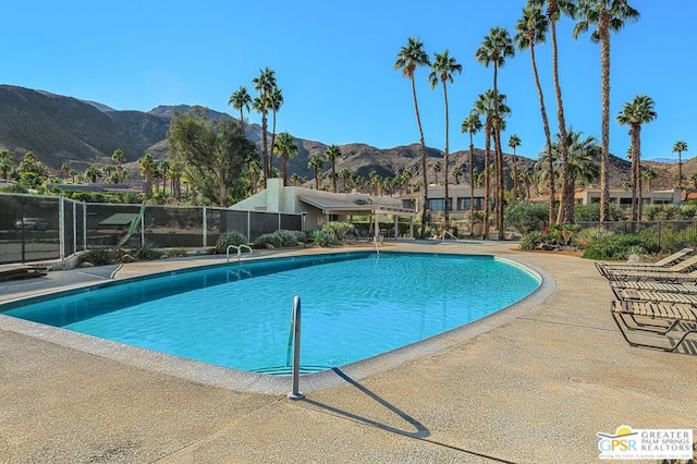 view of swimming pool with a mountain view and a patio area