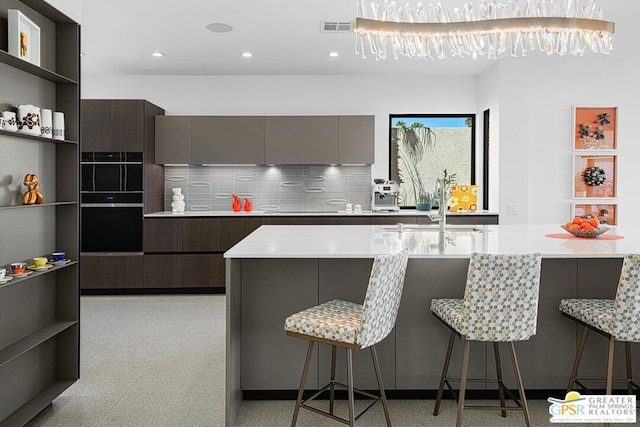 kitchen with sink, backsplash, and a kitchen bar