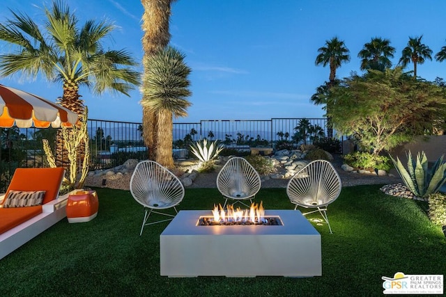 yard at dusk featuring an outdoor fire pit